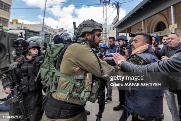 Palestinian protester and an Israeli soldier scuffle together during a "Land Day" demonstration in the Palestinian town of Huwara in the occupied...