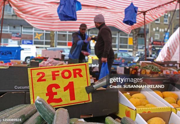 Sign displays the price in pound sterling of food goods, including cucumbers, at a a fruit and vegetable market in stall east London on March 31,...