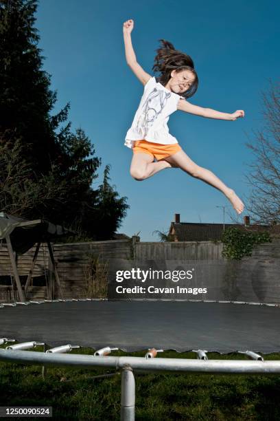 young girl jumping on trampoline in woking - england - girl trampoline stock pictures, royalty-free photos & images