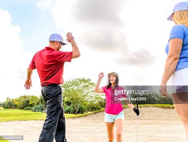 trio spielt golf auf einem schönen malerischen grün, mann und zwei frauen sportlich - golf bunker stock-fotos und bilder