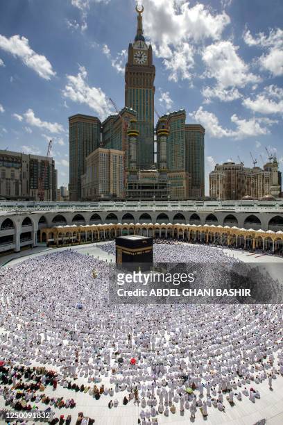 The Mecca Royal Clock Tower of the Abraj al-Bait skyscraper complex is seen in the background as Muslim worshippers pray around the Kaaba, Islam's...