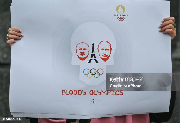 Protester in Krakow holds a powerful poster related to Summer Olympics in Paris and the words 'Bloody Olympics,' outside Krakow's Adam Mickiewicz...