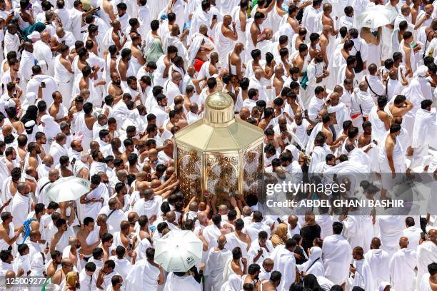 Muslim worshippers reach for a blessing as they touch the Maqam Ibrahim at the Grand Mosque in the holy city of Mecca during the second Friday...
