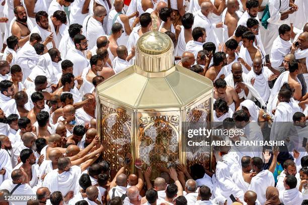 Muslim worshippers reach for a blessing as they touch the Maqam Ibrahim at the Grand Mosque in the holy city of Mecca during the second Friday...