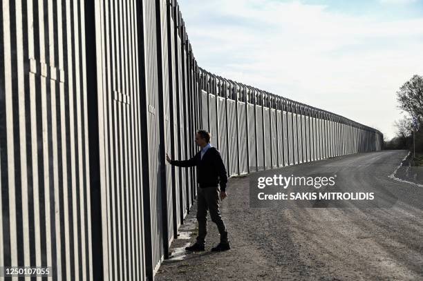 Greek prime minister Kyriakos Mitsotakis walks next to the steel fence during a ceremony marking the signing of the extension to the country's steel...