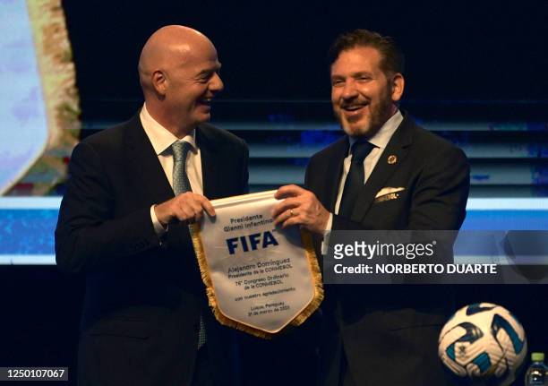 President Gianni Infantino presents Conmebol's president, Paraguayan Alejandro Dominguez with a commemorative pennant during Conmebol's 76th Ordinary...