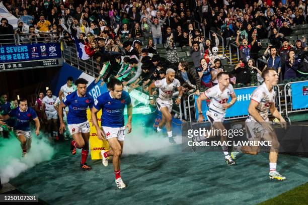 France's and Hong Kong's players run into the field during the first day of the Hong Kong Sevens rugby tournament on March 31, 2023.