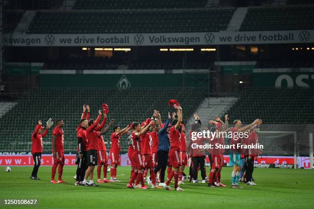 Players of Bayern Munich celebrate securing the Bundesliga title in front of empty stands following their victory in the Bundesliga match between SV...