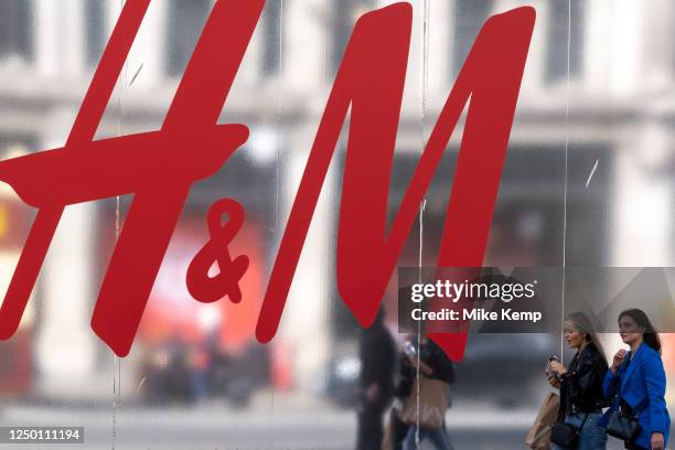 People passing a large scale sign for the high street clothes and clothing brand H&M outside their flagship store on the corner of Oxford Street and...
