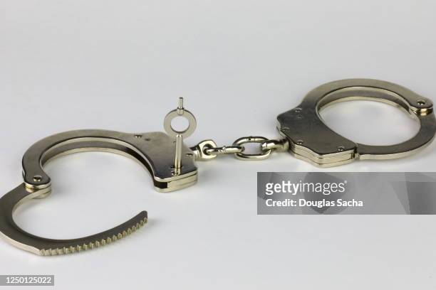 unlocked handcuffs on a white background - handcuffs imagens e fotografias de stock