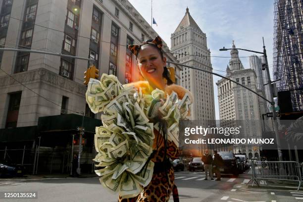 Woman wearing a costume made of dollar bills, stands outside the Manhattan District Attorney's office in New York City on March 31, 2023. - A New...