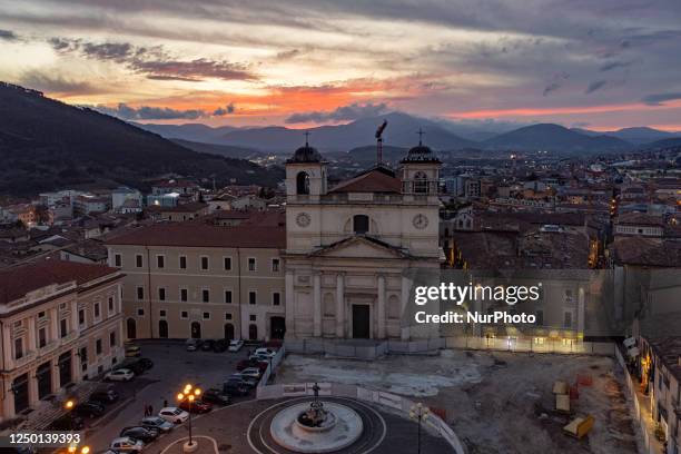 An aerial drone view shows sunset above San Massimo church in Piazza Duomo square in LAquila, Abruzzo, Italy, on March 31, 2023. On april 6 will...