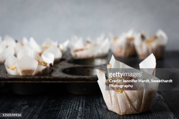 studio shot of a batch of rhubarb muffins in parchment paper cups - rabarber stockfoto's en -beelden