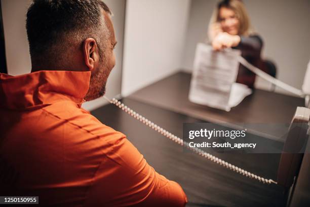 mannelijke gevangene die met zijn advocaat in gevangenisbezoekruimte spreekt - probatie stockfoto's en -beelden