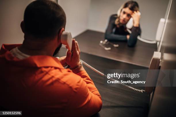 male prisoner talking with his sad wife in prison visit room - prisoner visit stock pictures, royalty-free photos & images