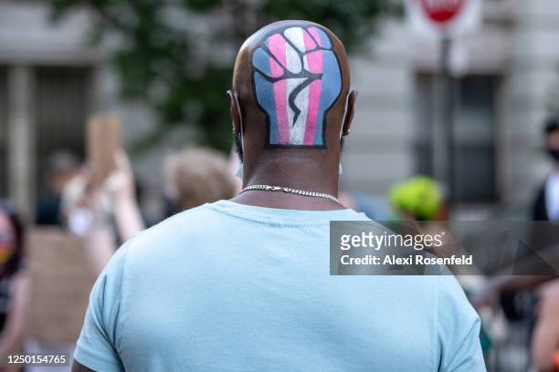 Person with a fist and transgender flag painted on the back of their head is seen at a Black Lives Matter Protest near the Stonewall Inn on June 16,...