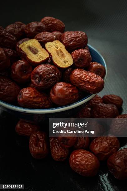 bowl of red dates and halved dates. - dates fruit stock pictures, royalty-free photos & images