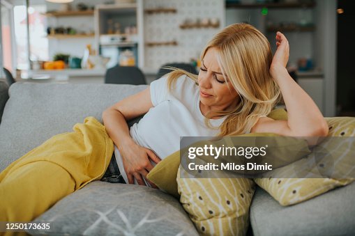 Femme avec des mains sur l’estomac souffrant de la photo de stock de douleur Femme avec des mains sur l’estomac souffrant de la photo de stock de douleur