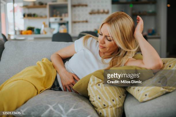 woman with hands on stomach suffering from pain stock photo - tender imagens e fotografias de stock