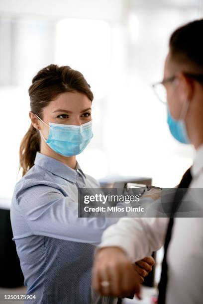 business people greeting during covid-19 pandemic stock photo - covid handshake stock pictures, royalty-free photos & images