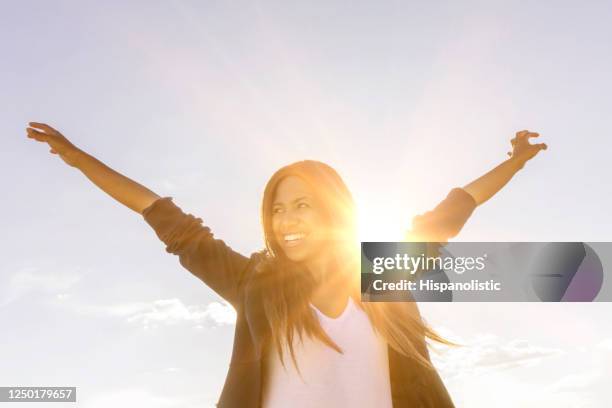 屋外で太陽の光を楽しむ幸せな女性 - 覚悟 ストックフォトと画像