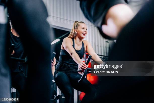 lächelnde sportliche frau radfahren im gesundheitsclub - spinning stock-fotos und bilder