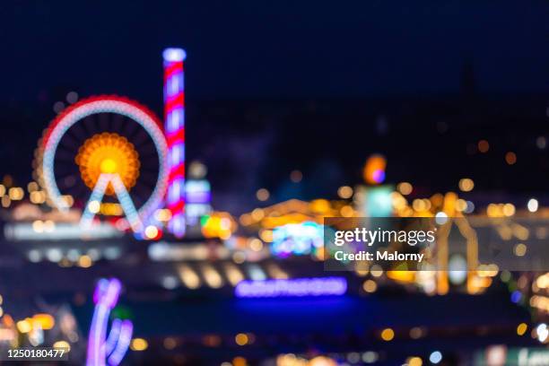 panoramic defocused view of the munich beer fest at night. germany, bavaria, munich. - fair ground lights stock pictures, royalty-free photos & images