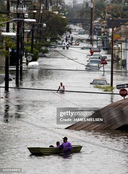 Residents wade through a flooded street in New Orleans, 29 August 2005, after hurricane Katrina made landfall. Hurricane Katrina made landfall early...