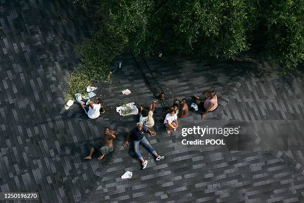 Disaster Stranded People People sit stranded on a roof in the aftermath of Hurricane Katrina ...