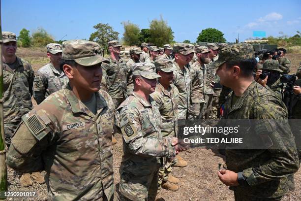 This photo taken on March 31, 2023 shows Brigadier General Francis Coronel , of Philippine army artillery regiment, shaking hands with US army...