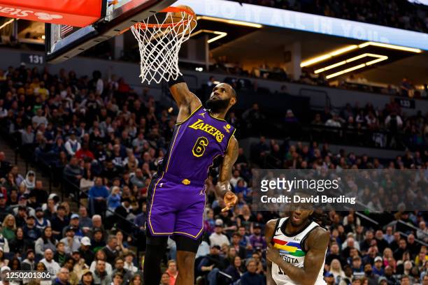 LeBron James of the Los Angeles Lakers dunks the ball as Taurean Prince of the Minnesota Timberwolves reacts in the second quarter of the game at...