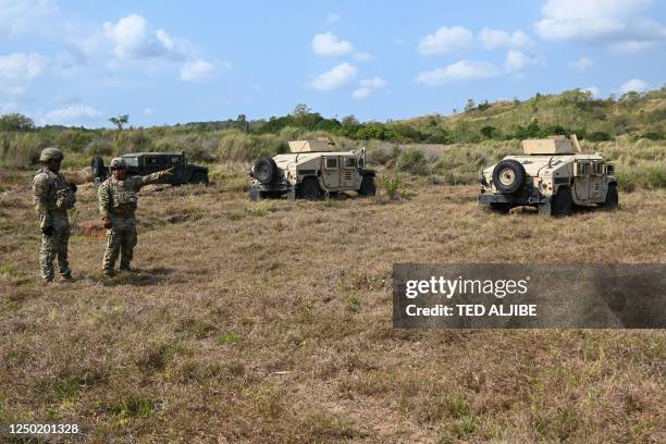This photo taken on March 31, 2023 shows US army soldiers standing next to their humvies prior to a live fire exercise during the joint exercise...