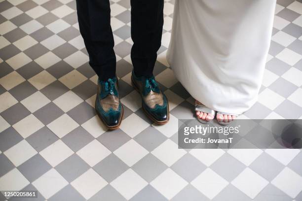bride and groom with their shoes on cube pattern floor - mens black dress shoes stock pictures, royalty-free photos & images