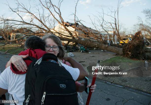 Residents embrace while evacuating their neighborhood after a large tornado damaged hundreds of homes and buildings on March 31, 2023 in Little Rock,...