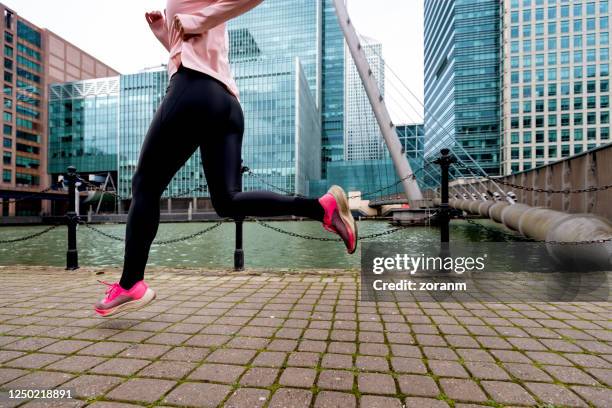 sección baja de mujer corriendo en el entorno urbano - london docklands fotografías e imágenes de stock