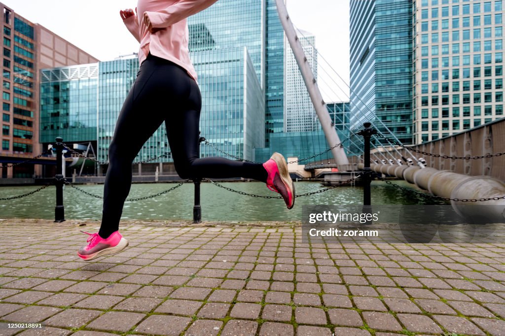 Low section of woman jogging in urban enviroment