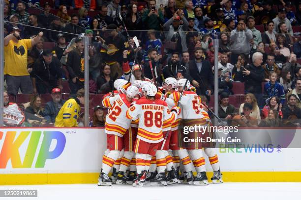 The Calgary Flames celebrate after defeating the Vancouver Canucks in overtime during their NHL game at Rogers Arena on March 31, 2023 in Vancouver,...