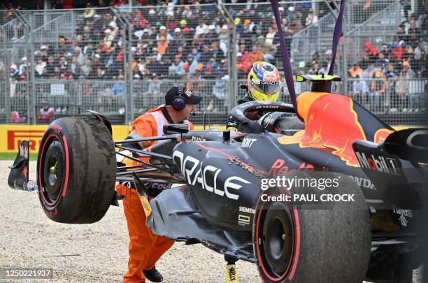 Marshal assits in removing Red Bull Racing's Mexican driver Sergio Perez car from the side of track during the qualifying round of the 2023 Formula...