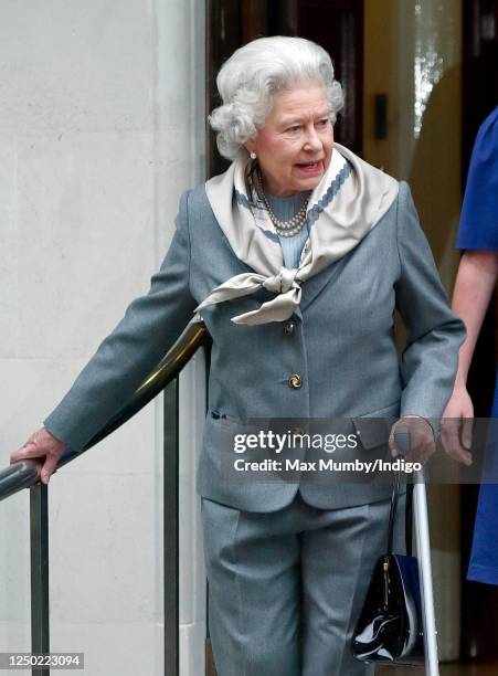 Queen Elizabeth II, seen wearing trousers and using a crutch, leaves the King Edward VII Hospital after undergoing knee surgery on January 14, 2003...