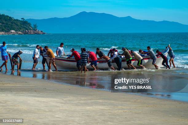 fischer, bootsleute und kameraden, sammeln das fischerboot nach einer belagerung der mullets - florianopolis stock-fotos und bilder