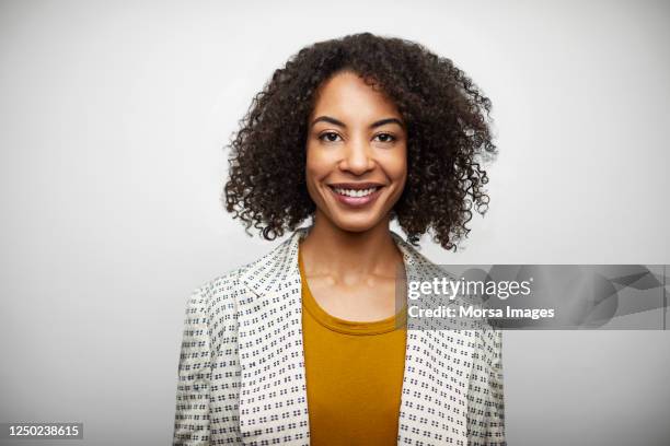 portrait of smiling mid adult woman in casuals - african american businesswoman isolated stockfoto's en -beelden