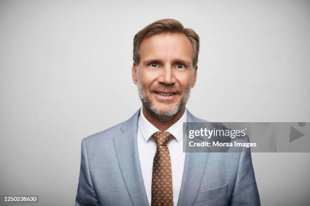 smiling mature male leader wearing blue suit. - full suit stock pictures, royalty-free photos & images