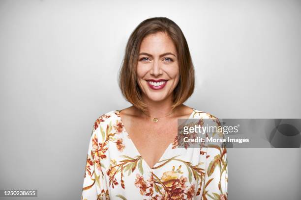 portrait of smiling mid adult woman in casuals - portrait stock-fotos und bilder