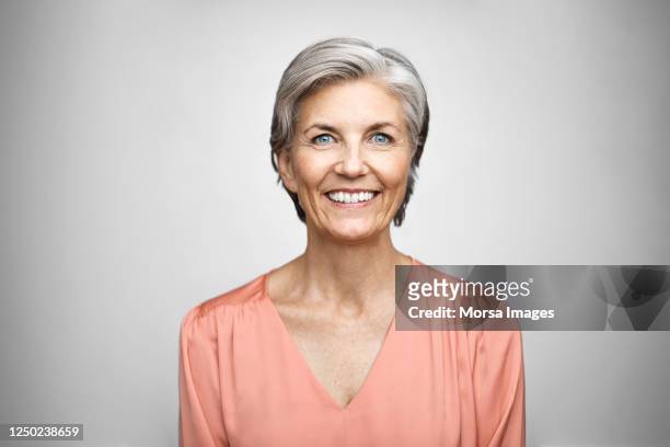portrait of smiling senior executive. - eine frau allein stock-fotos und bilder