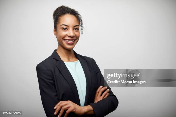 mid adult female entrepreneur with arms crossed. - black blazer stock pictures, royalty-free photos & images