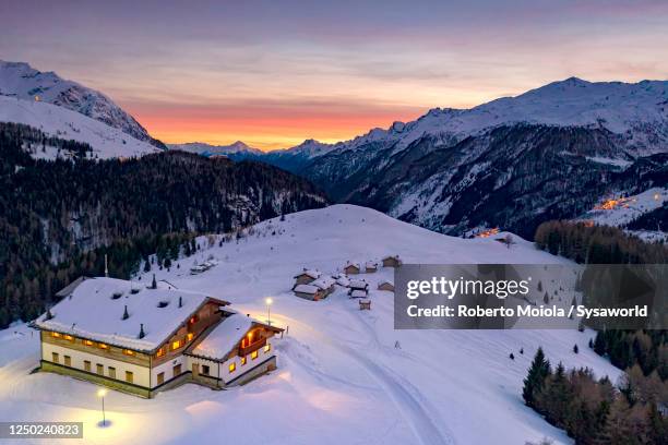 snowy mountain huts at sunset, andossi, madesimo, italy - lombardei stock-fotos und bilder