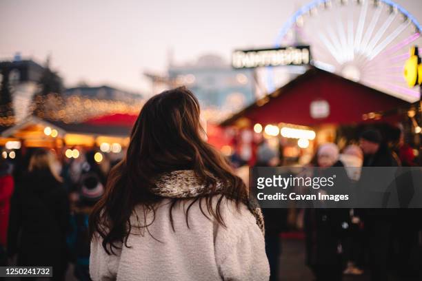 back view of teenage girl enjoying city during christmas - mid adult women photos et images de collection