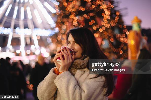 happy teenage girl drinking mulled wine in christmas market - julmarknad bildbanksfoton och bilder