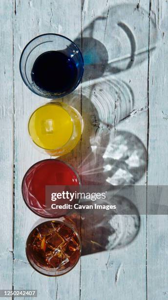 different coloured drinks in a glass on a white wooden base - 食品添加物 ストックフォトと画像