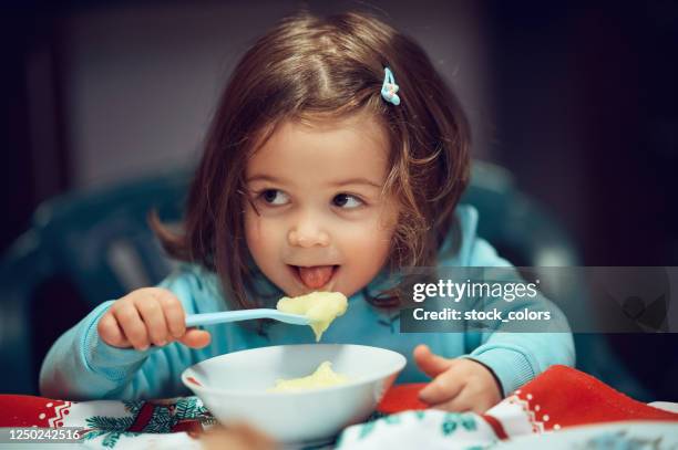 baby girl eating mashed potatoes - mashed potatoes stock pictures, royalty-free photos & images